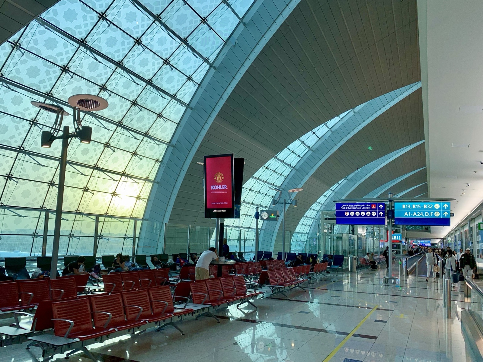 The bright, high-ceilinged arrivals hall of Dubai International Airport, Terminal 3.